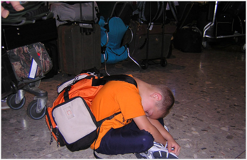 Austin asleep on the London Heathrow airport floor
