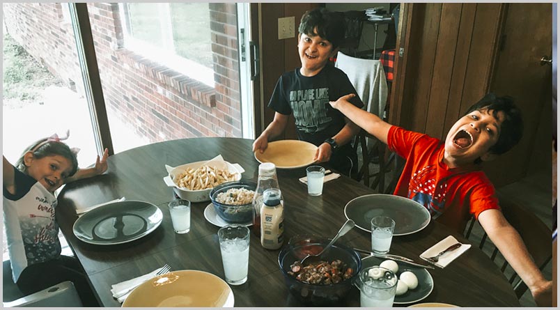 A photo of Jayden, Edson, and Hadasa Tejeda around the dinner table