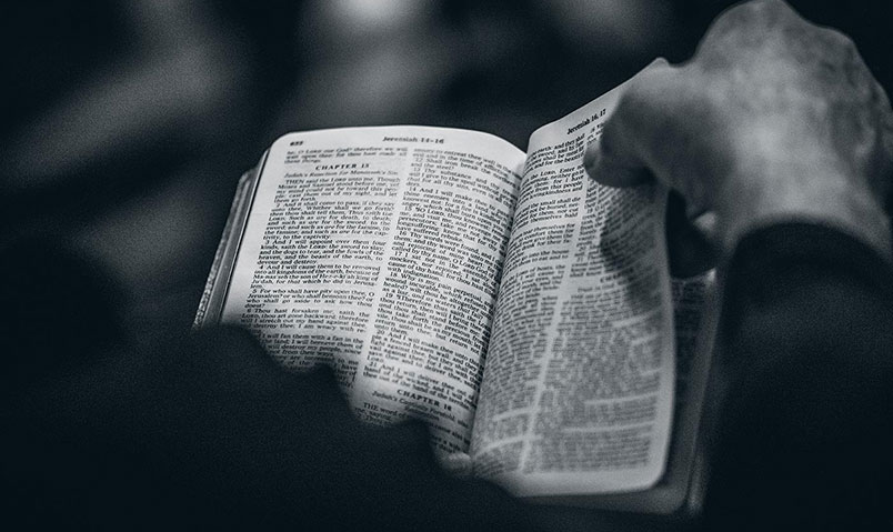 A photo of a man reading a Bible