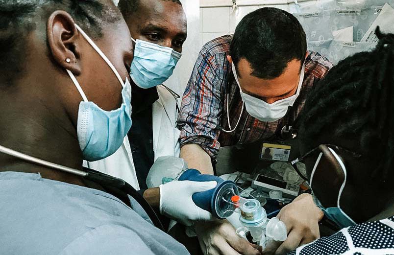 A team of four medical personnel working on a patient