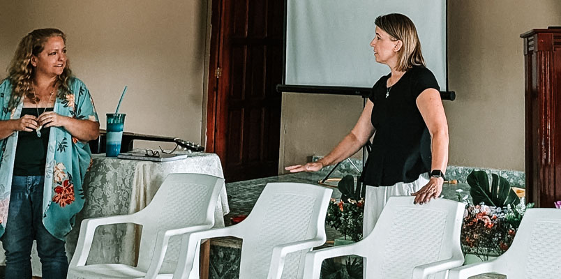 Kelly Solheim and Peggy talking to each other at the front of a church
