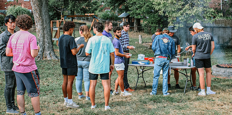 Students standing in line to get food, at a Global Cafe cookout