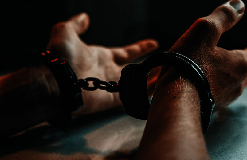 handcuffed wrists on a table with palms facing up