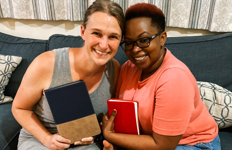 Two beaming women holding Bibles