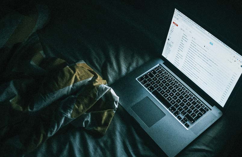 An open laptop on a bed